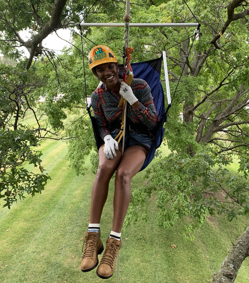 Young climber smiling in the tree canopy